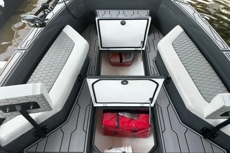 Slide: The Image of 2024 H-Craft 27 CC boat interior with open storage compartments and cushioned seating. - 31