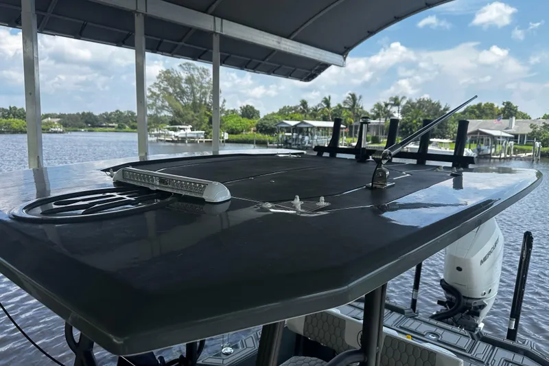 Slide: The Image of 2024 H-Craft 27 CC boat roof with antenna and light, docked by a scenic waterfront. - 39