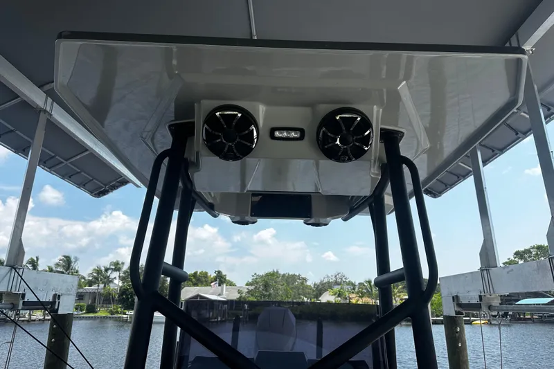 Slide: The Image of 2024 H-Craft 27 CC boat with speakers and canopy, docked by the water. - 43