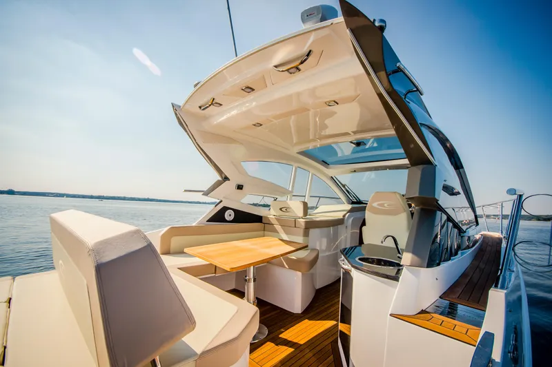 Slide: The Image of Luxurious 2026 Cobrey 33 HT yacht interior with seating and table on open water. - 6