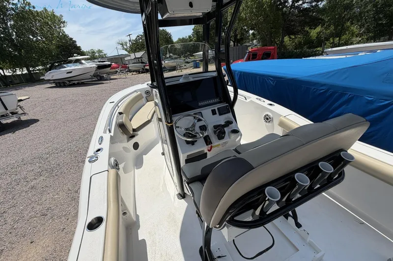Slide: The Image of 2020 Tidewater 232 CC Adventure boat interior with helm, seating, and rod holders. - 20