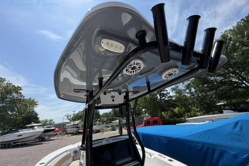 Slide: The Image of 2020 Tidewater 232 CC Adventure boat with T-top and rod holders, docked outdoors. - 21