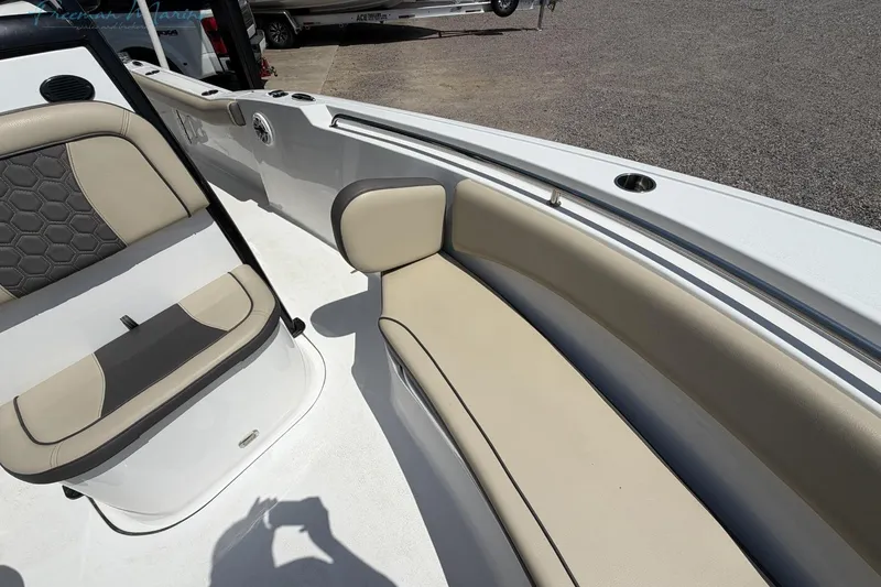 Slide: The Image of 2020 Tidewater 232 CC Adventure boat interior with beige seating and cup holders. - 7