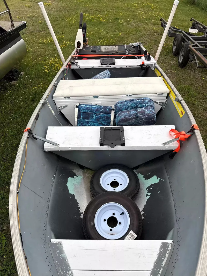 Slide: The Image of A 1971 Lund FISH boat with blue seats and two spare tires on board. - 3