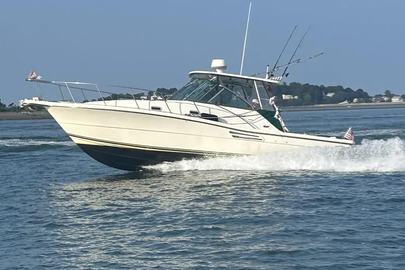 Slide: The Image of 2002 Pursuit 3000 Express boat cruising on open water, clear sky background. - 2