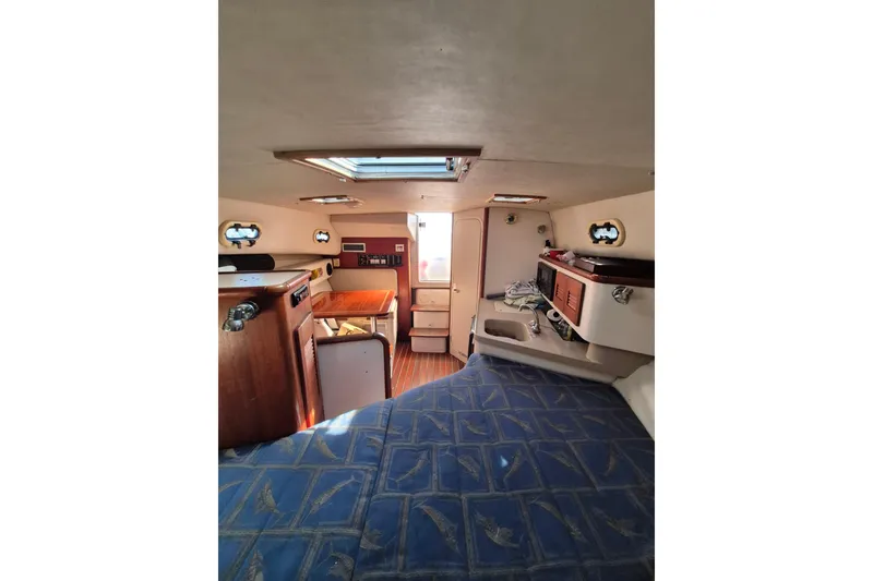 Slide: The Image of Interior of a 2002 Pursuit 3000 Express boat, featuring a cozy cabin layout. - 3