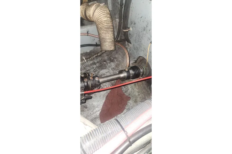 Slide: The Image of Engine compartment of a 1985 Bertram 33 Flybridge Cruiser, showing mechanical components and hoses. - 13