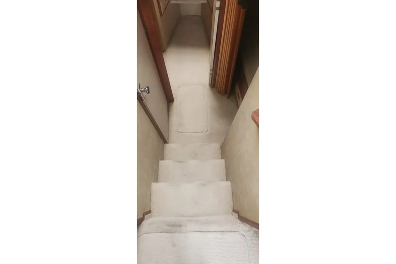 Slide: The Image of Carpeted stairs inside a 1985 Bertram 33 Flybridge Cruiser yacht. - 15