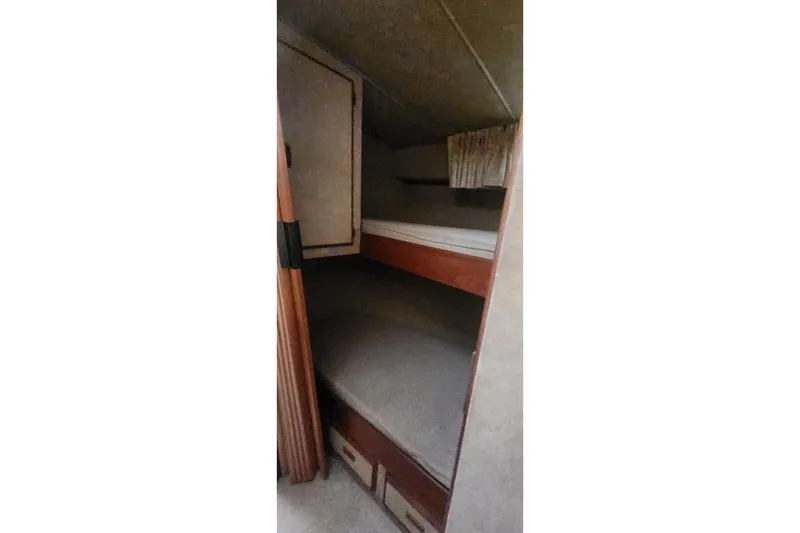 Slide: The Image of Interior cabin view of 1985 Bertram 33 Flybridge Cruiser with bunk beds and storage. - 16