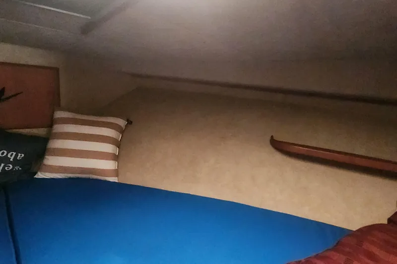 Slide: The Image of Interior cabin of 1985 Bertram 33 Flybridge Cruiser with striped pillow and blue bedding. - 19