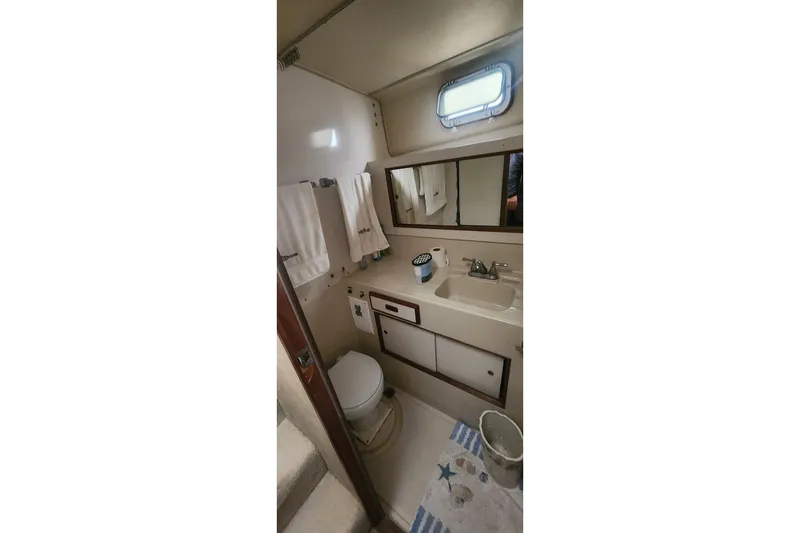 Slide: The Image of Bathroom interior of 1985 Bertram 33 Flybridge Cruiser with sink, mirror, and toilet. - 21