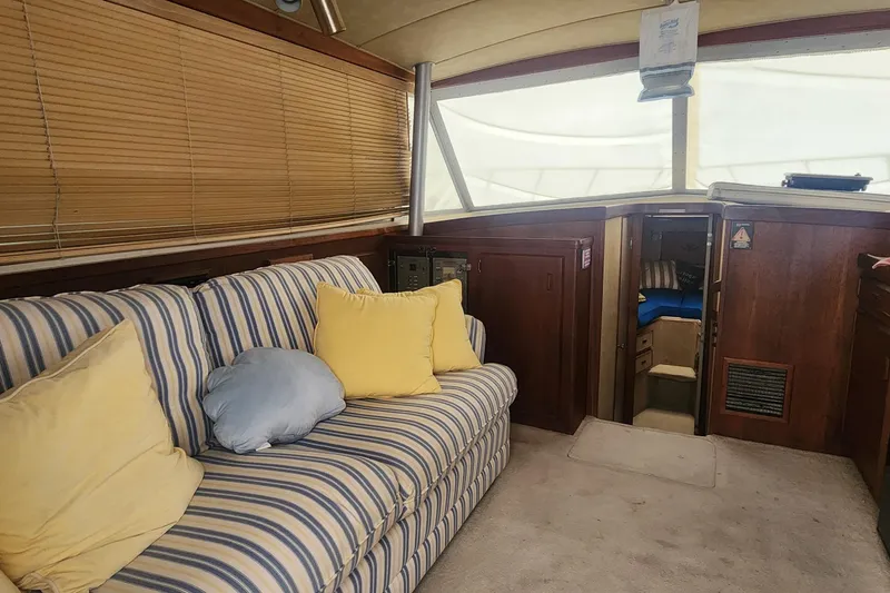 Slide: The Image of Interior of 1985 Bertram 33 Flybridge Cruiser with striped sofa and wooden accents. - 28