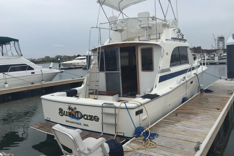 Slide: The Image of 1985 Bertram 33 Flybridge Cruiser docked, featuring "Sun Daze" name and Braintree, MA location. - 5