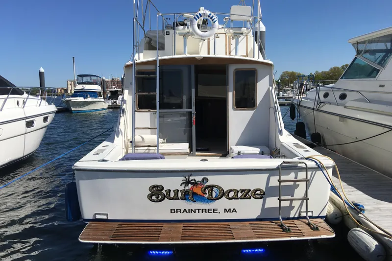Slide: The Image of 1985 Bertram 33 Flybridge Cruiser docked, featuring "Sun Daze" name, Braintree, MA. - 6