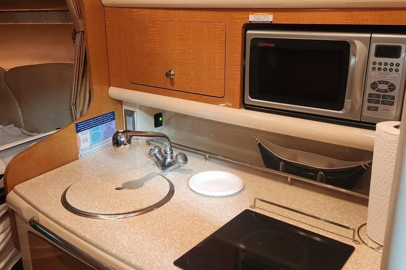 Slide: The Image of 2006 Chaparral 290 Signature boat kitchen with sink, microwave, and countertop. - 12