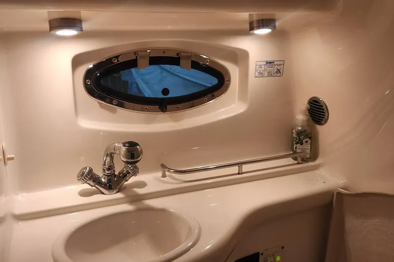 Slide: The Image of 2006 Chaparral 290 Signature boat bathroom with sink, faucet, and porthole window. - 14
