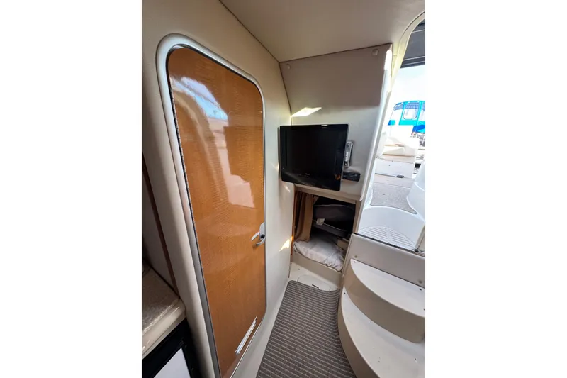 Slide: The Image of Interior of 2006 Chaparral 290 Signature boat with wooden door and mounted TV. - 15