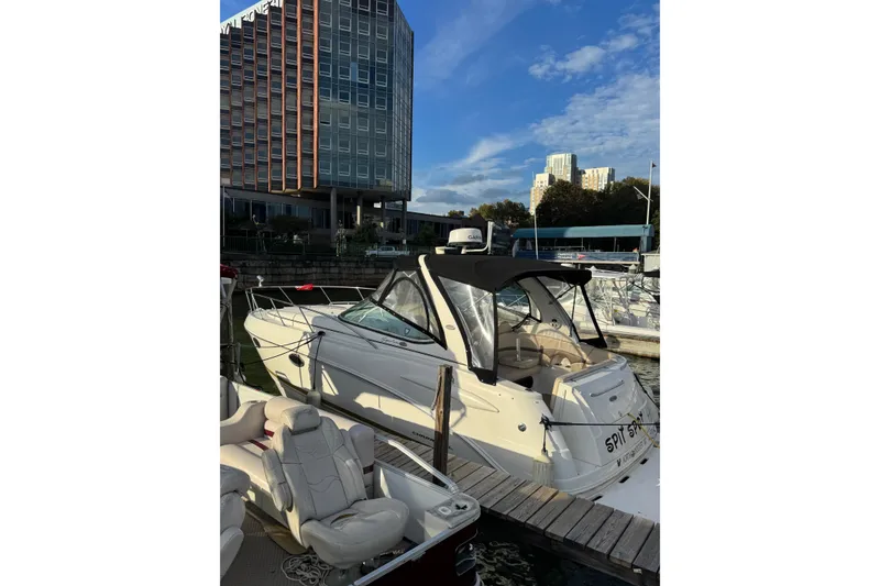 Slide: The Image of 2006 Chaparral 290 Signature boat docked near modern building under blue sky. - 6