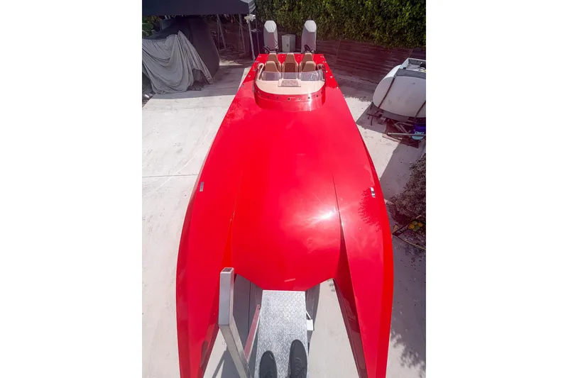 Slide: The Image of 2025 Bravo Powerboats XP 30, sleek red design, parked outdoors. - 2
