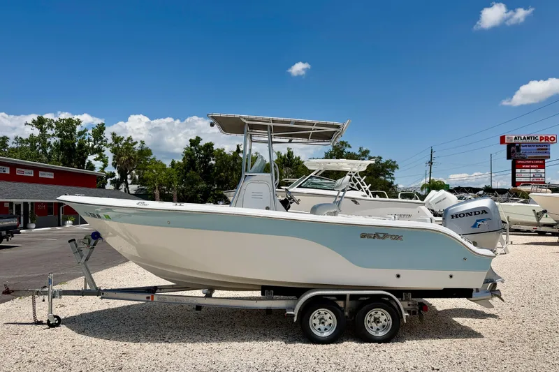 The Image of 2009 Sea Fox 216 Center Console boat on trailer, displayed outdoors under clear blue sky. - 0