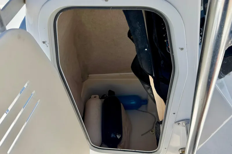 Slide: The Image of Storage compartment of a 2009 Sea Fox 216 Center Console boat, containing life jackets and a fender. - 27