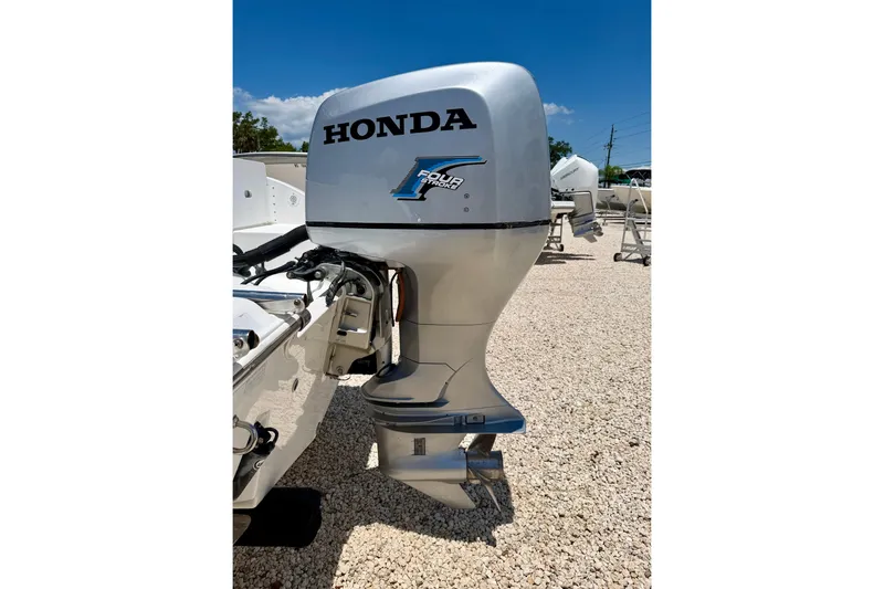 Slide: The Image of Honda outboard motor on a 2009 Sea Fox 216 Center Console boat, parked on gravel. - 29