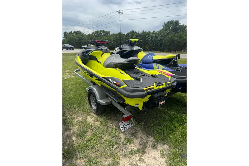Slide: The Image of 2020 Sea-Doo RXT-X 300 jet ski on trailer, parked on grass. - 2