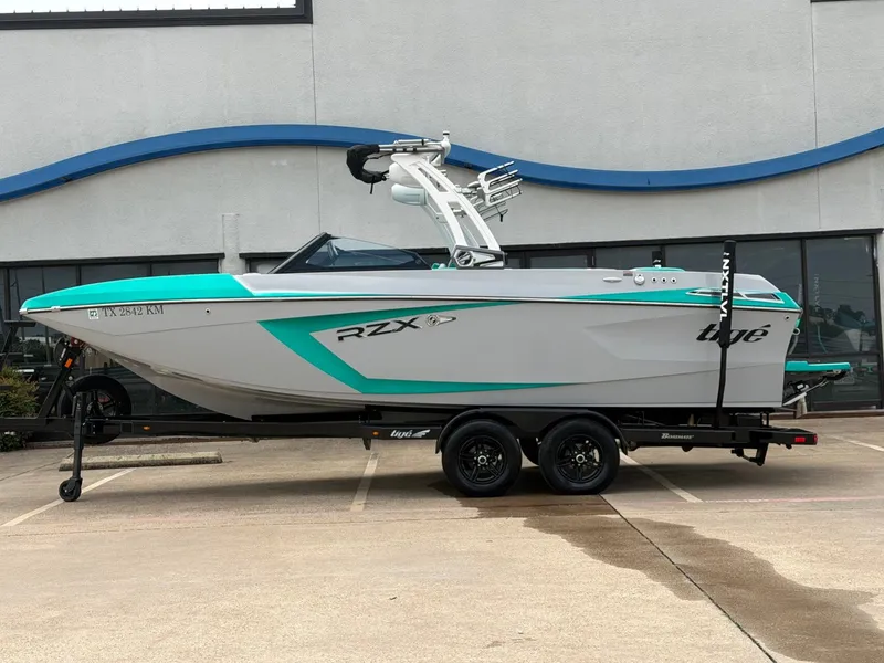 The Image of 2021 Tigé 23RX boat on trailer in front of building. - 1