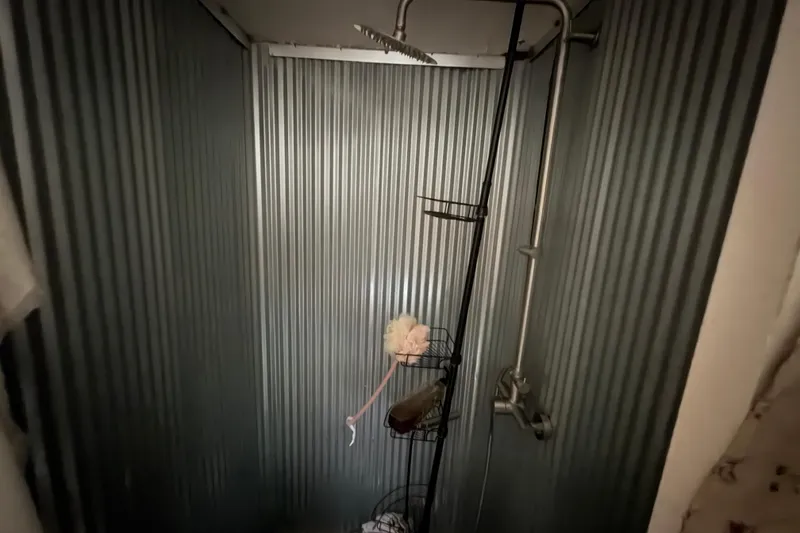 Slide: The Image of Shower area with corrugated metal walls in a 1997 Catamaran Cruisers 44' Aqua Cruiser. - 10