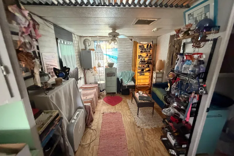 Slide: The Image of Interior of a 1997 Catamaran Cruisers 44' Aqua Cruiser, featuring cozy decor and storage. - 6