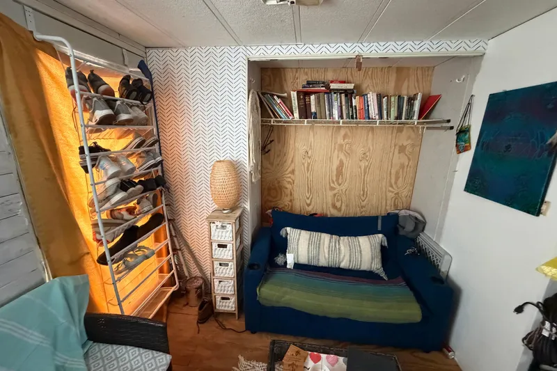 Slide: The Image of Cozy interior of 1997 Catamaran Cruisers 44' Aqua Cruiser with books, shoes, and seating. - 7