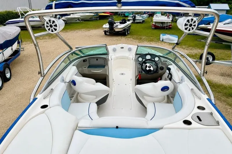 Slide: The Image of 2007 Rinker 226 Captiva Bowrider interior with seating and steering wheel, parked outdoors. - 4