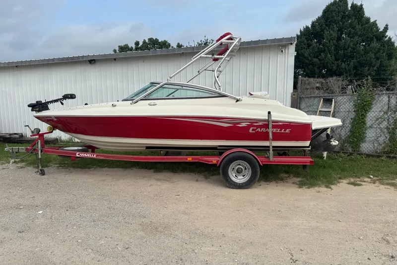 The Image of 2006 Caravelle 207LS Bow Rider boat on trailer, parked outdoors. - 0