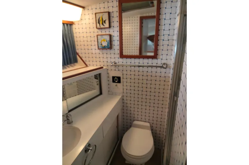 Slide: The Image of Bathroom interior of a 1978 Bertram 46.6 yacht with nautical decor and tiled walls. - 17