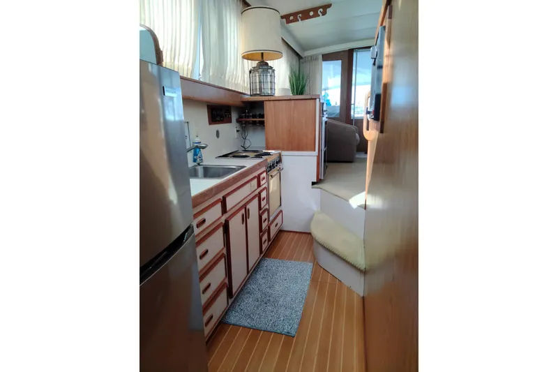 Slide: The Image of 1978 Bertram 46.6 yacht interior kitchen with wooden cabinets and stainless steel appliances. - 19