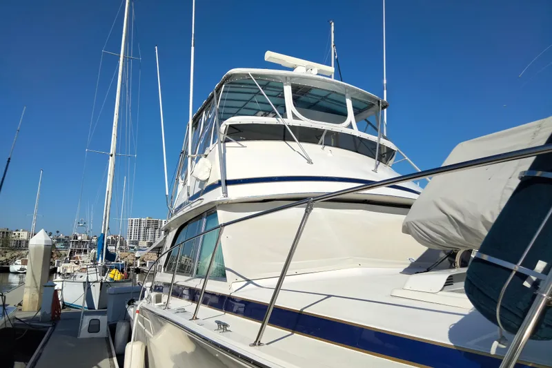 Slide: The Image of 1978 Bertram 46.6 yacht docked at marina under clear blue sky. - 2