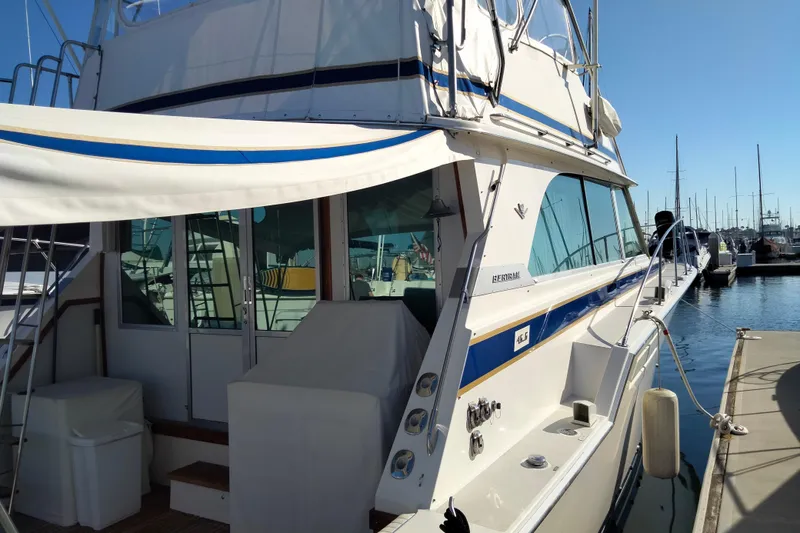 Slide: The Image of 1978 Bertram 46.6 yacht docked at marina, featuring classic design and spacious deck. - 3