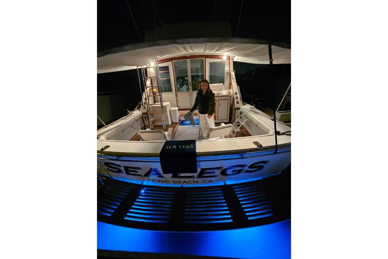 Slide: The Image of 1978 Bertram 46.6 yacht "Sea Legs" docked at night with blue underwater lights. - 6