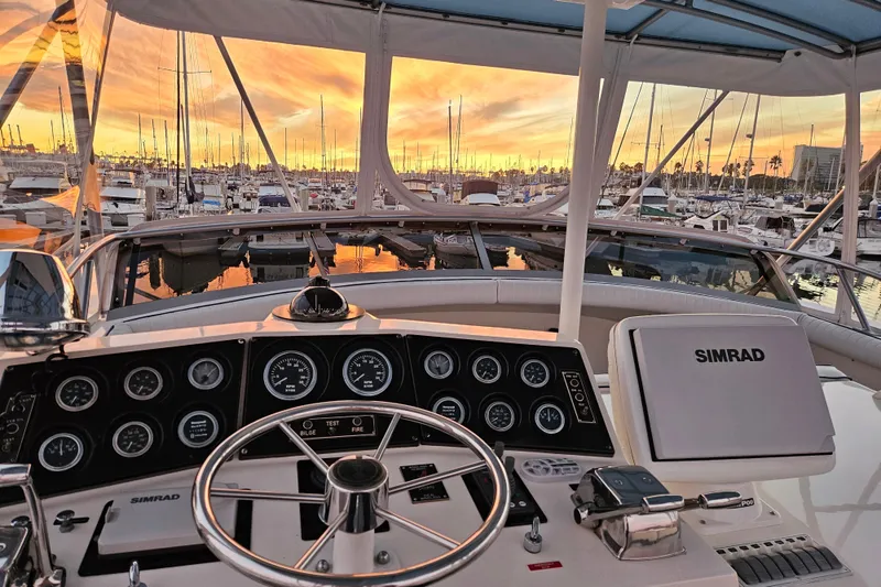 Slide: The Image of Cockpit view of a 1978 Bertram 46.6 yacht at sunset in a marina. - 7