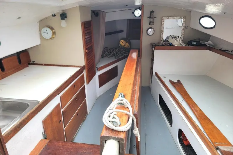 Slide: The Image of Interior of a 1974 Marshall 22 Catboat with wooden cabinetry and nautical decor. - 1