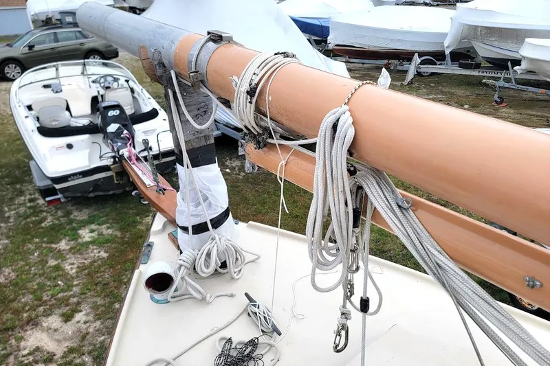 Slide: The Image of 1974 Marshall 22 Catboat mast and rigging, with boats in the background. - 12