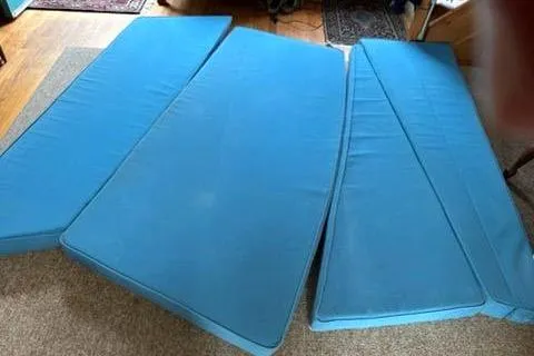 Slide: The Image of Blue cushions for a 1974 Marshall 22 Catboat, arranged on a carpeted floor. - 27