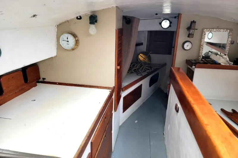 Slide: The Image of Interior of a 1974 Marshall 22 Catboat, featuring wooden cabinetry and nautical decor. - 4