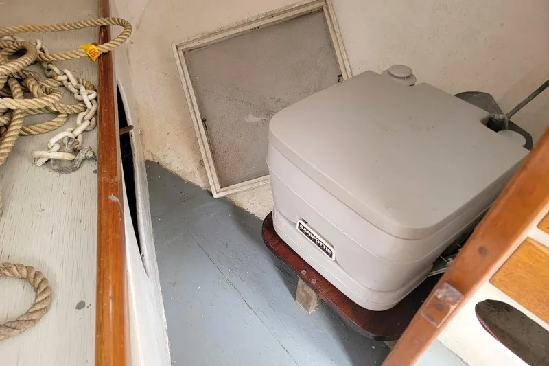 Slide: The Image of 1974 Marshall 22 Catboat interior with portable toilet and coiled ropes. - 7
