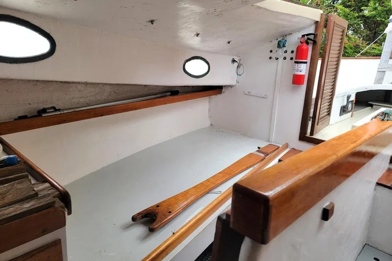 Slide: The Image of Interior of a 1974 Marshall 22 Catboat, featuring wooden accents and a fire extinguisher. - 8