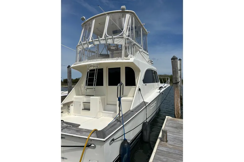 The Image of 1990 Post 46 Convertible yacht docked, featuring a spacious deck and flybridge under clear skies. - 0