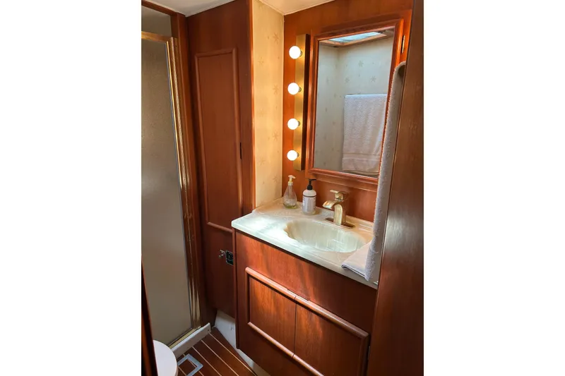 Slide: The Image of Luxurious 1990 Post 46 Convertible yacht bathroom with wood accents and vanity lighting. - 11