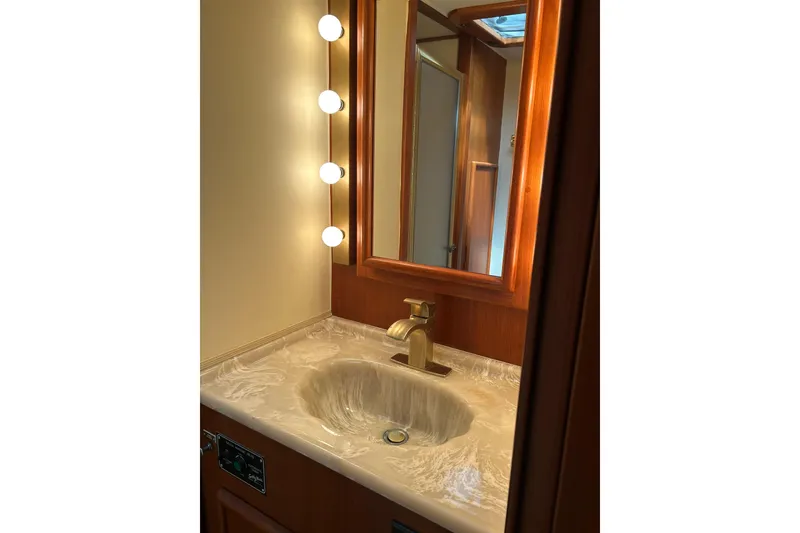 Slide: The Image of Luxurious bathroom vanity with marble sink and mirror lighting in 1990 Post 46 Convertible. - 12