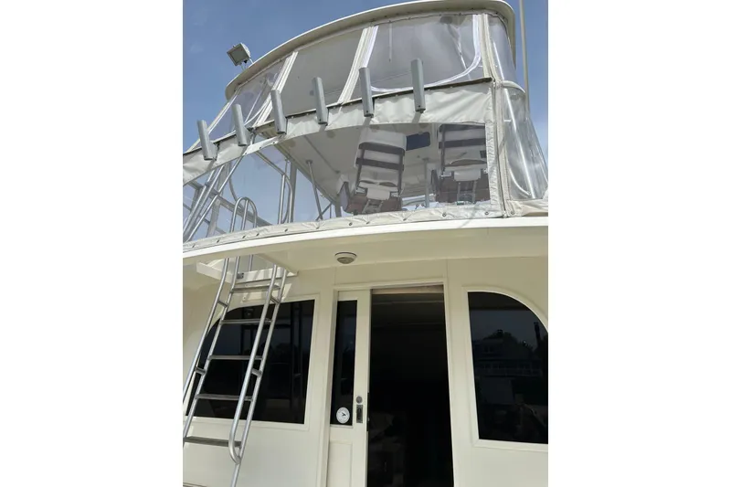 Slide: The Image of 1990 Post 46 Convertible yacht with upper deck and ladder, featuring enclosed seating area. - 16