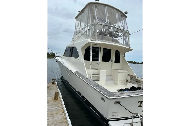 Slide: The Image of 1990 Post 46 Convertible yacht docked, featuring spacious deck and enclosed flybridge. - 21